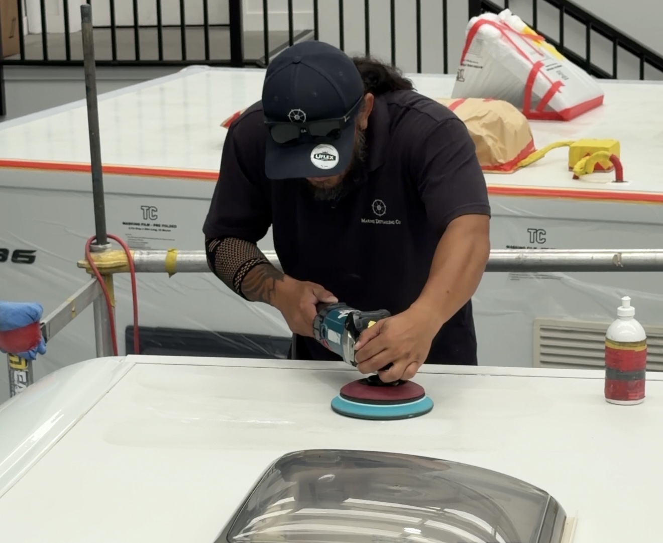 Technician polishing a motorhome roof inside the workshop