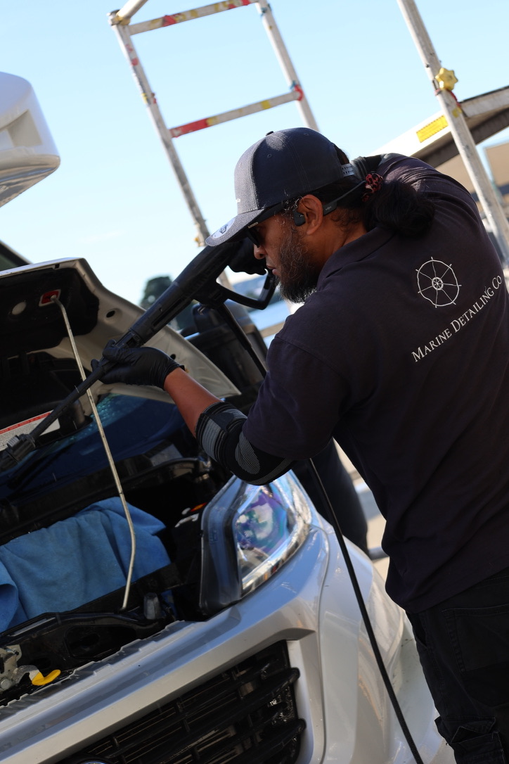 Marine Detailing Co technician steam cleaning the engine bay of a motorhome cab