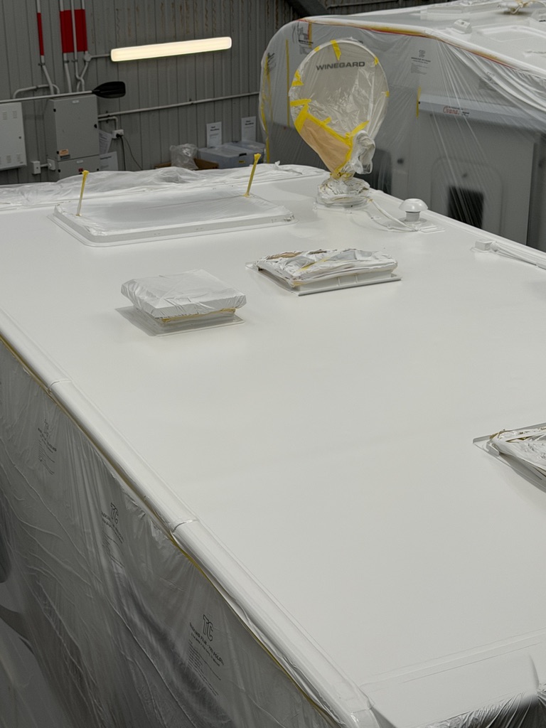 Freshly applied Noxyde waterproof membrane on a motorhome roof with vents and antenna masked off